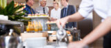 Four Smiling Business People at Buffet Table